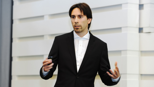 © Nicolas Maack | Sebastian Bathiany hält einen Vortrag vor einer hellen Wand.
